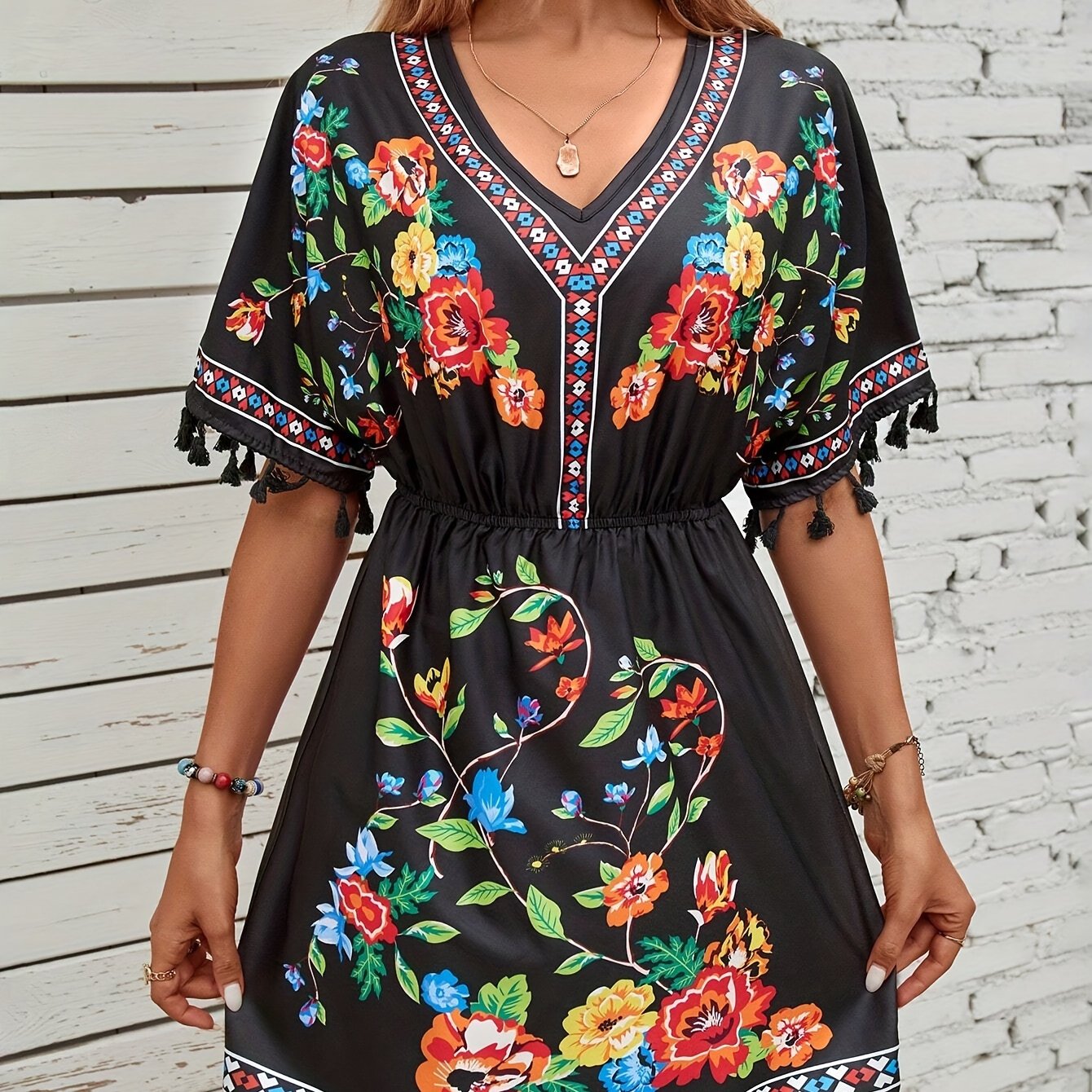 Abito con scollo a punta, motivo a quadri e nappe, eleganti maniche corte